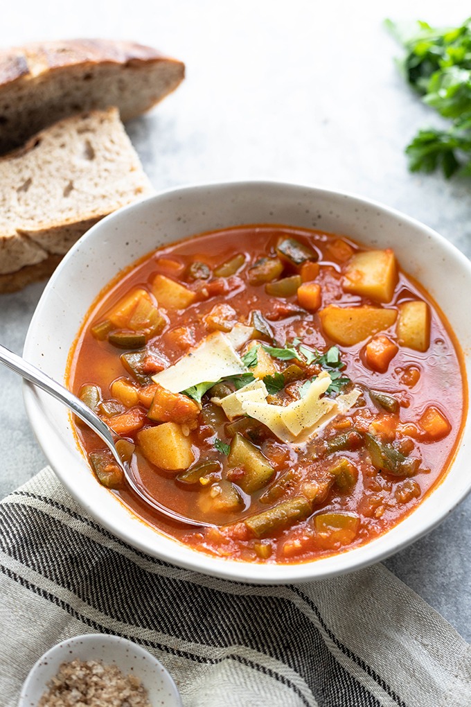 minestrone in a bowl with bread and parsley 