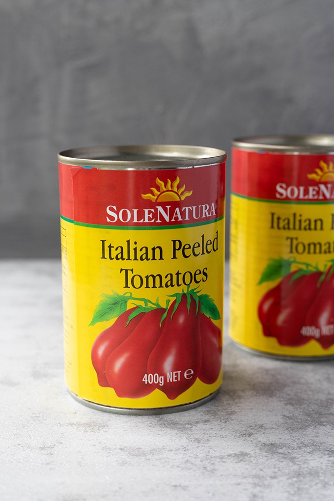 two tins of tomatoes on grey board