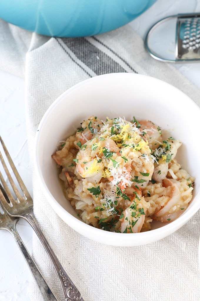 prawn risotto in a white bowl with two antique forks